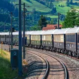 Luxuriöser Zug fährt durch grüne Hügel, auf dem Weg nach Mailand.