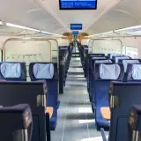 Leere Sitze in einem modernen Zugabteil. Die blauen Polster mit hellblauen Kopfkissen laden zur entspannten train ride ein.