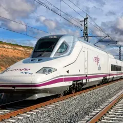 Weißer Hochgeschwindigkeitszug AVE von Renfe fährt auf Gleisen.