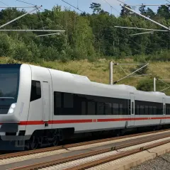Moderner ICE-Zug fährt durch eine grüne Landschaft in Deutschland. Der Zug ist bereit für den Fernverkehr.