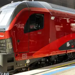 Roter Railjet Express Zug steht am Bahnsteig.