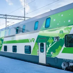 Zweisstöckige Züge von VR in Finnland mit Eulen-Design auf verschneiter Plattform.