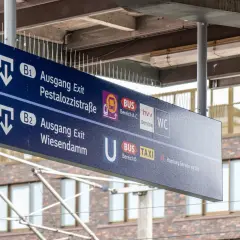 Wegweiser an einem Bahnsteig: Ausgang B1 zur Pestalozzistraße, B2 zum Wiesendamm, Bus, Taxi und WC.