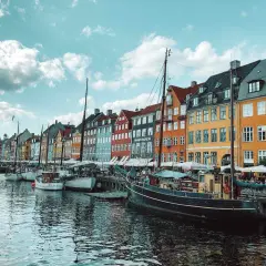 Bunte Häuser am Nyhavn-Kanal in Kopenhagen, Dänemark. Boote liegen im Wasser, ein perfekter Ort nach der **train to Copenhagen**.
