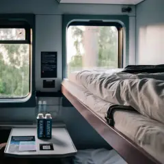 Frau blickt aus dem Fenster im Schlafwagen. Die Reise von München nach Brüssel beginnt.