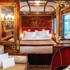 Luxuriöses Schlafabteil im Orient Express mit Doppelbett, Spiegeln und Mahagoni-Verzierungen.