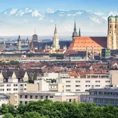 Blick auf München mit Alpen im Hintergrund. Die Zugfahrt von Köln nach München ist eine Reise durch Deutschland.
