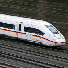 Schneller ICE-Zug mit deutscher Flagge auf der Seite rast auf den Gleisen. Die Reise von Paris nach Zürich beginnt.