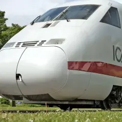 Der weiße ICE-Zug, ein deutscher Hochgeschwindigkeitszug, steht auf Gleisen im Gras.