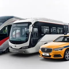 Moderner Zug, Bus und gelber Taxi in Slowenien.