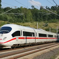 Ein weißer ICE mit roten Streifen fährt auf den Gleisen Richtung Tunnel. Die Fahrt von Frankfurt nach Basel beginnt.