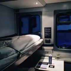 Gemütliches Schlafwagenabteil für die Reise von Hamburg nach Rom. Das Bett ist gemacht, bereit für eine erholsame Nacht.
