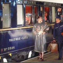 Luxuriöser Zug für die Reise von Venedig nach Florenz. Ein Schaffner hilft einer Dame mit Gepäck beim Einsteigen.
