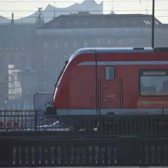 Roter Zug der Bahn Hamburg fährt durch die Stadt. Eine Reise mit dem Zug durch Deutschland beginnt hier.