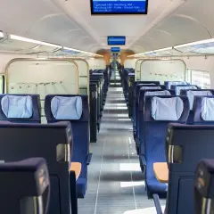 Leere Sitze in einem modernen Zugabteil. Die blauen Polster mit hellblauen Kopfkissen laden zur entspannten train ride ein.