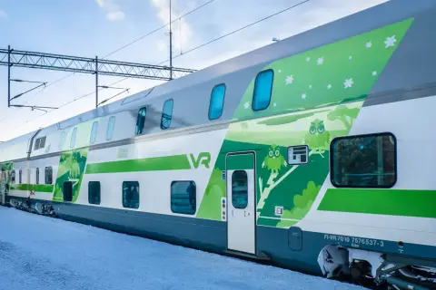 Zweisstöckige Züge von VR in Finnland mit Eulen-Design auf verschneiter Plattform.