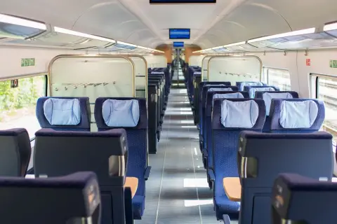 Leere Sitze in einem modernen Zugabteil. Die blauen Polster mit hellblauen Kopfkissen laden zur entspannten train ride ein.