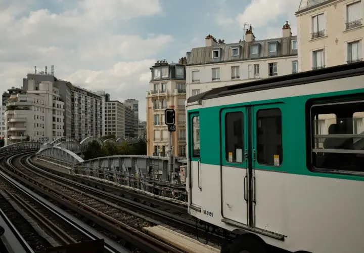Ein Pariser Zug fährt auf erhöhten Gleisen an Gebäuden vorbei. Vielleicht ist dies der Ort, um den Bahnhof zu wechseln.