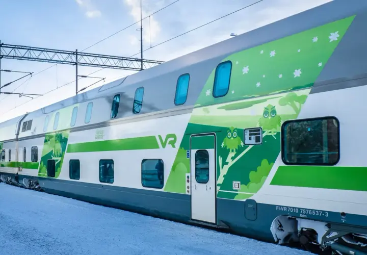 Zweisstöckige Züge von VR in Finnland mit Eulen-Design auf verschneiter Plattform.