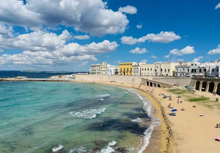 Sonne, Strand und Meer – ein gut mit Zug erreichbares Paradies. Türkisfarbenes Wasser trifft auf Sandstrand und weiße Häuser.
