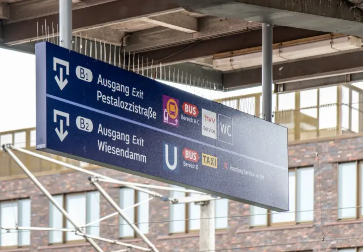 Wegweiser an einem Bahnsteig: Ausgang B1 zur Pestalozzistraße, B2 zum Wiesendamm, Bus, Taxi und WC.