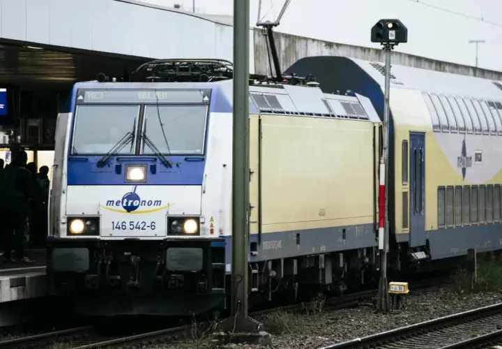 Ein Metronom-Zug in Deutschland steht am Bahnsteig. Reisende warten auf die Abfahrt nach Uelzen.