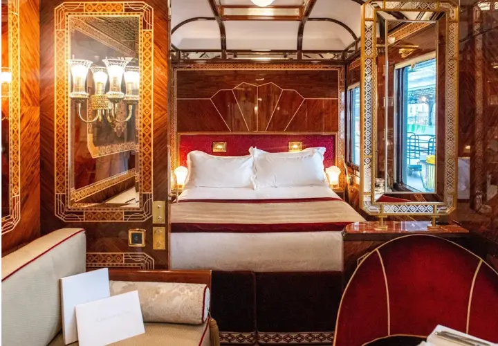 Luxuriöses Schlafabteil im Orient Express mit Doppelbett, Spiegeln und Mahagoni-Verzierungen.