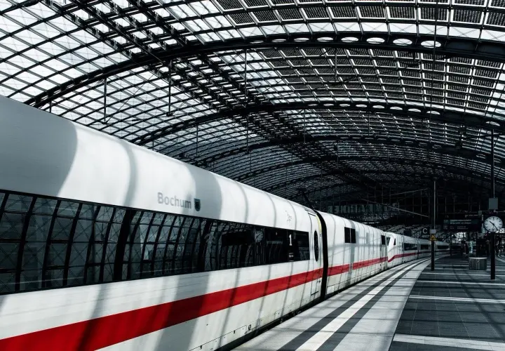 Ein ICE-Zug mit der Aufschrift "Bochum" steht unter dem beeindruckenden Glasdach eines Bahnhofs. Perfekt für einen Wochenendtrip von Berlin mit Zug.