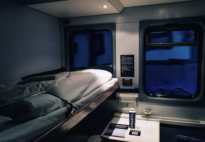 Gemütliches Schlafwagenabteil für die Reise von Hamburg nach Rom. Das Bett ist gemacht, bereit für eine erholsame Nacht.