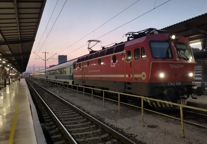 Roter Zug mit HZ PP Logo am Zagreb Hauptbahnhof im Abendlicht.
