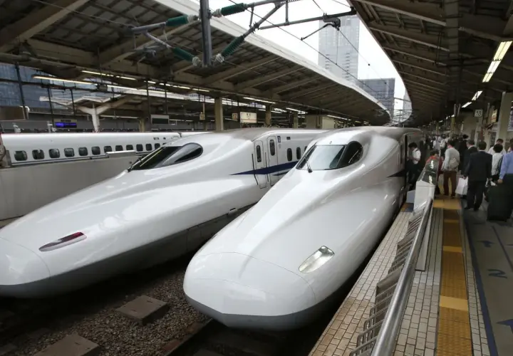 Zwei weiße Shinkansen-Züge stehen nebeneinander auf einem Bahnhof. Sie sind ein Symbol für die effizienten Zugverbindungen Japans.