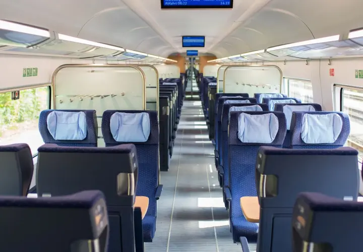 Leere Sitze in einem modernen Zugabteil. Die blauen Polster mit hellblauen Kopfkissen laden zur entspannten train ride ein.