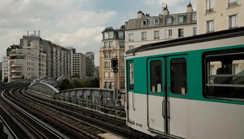 Ein Pariser Zug fährt auf erhöhten Gleisen an Gebäuden vorbei. Vielleicht ist dies der Ort, um den Bahnhof zu wechseln.