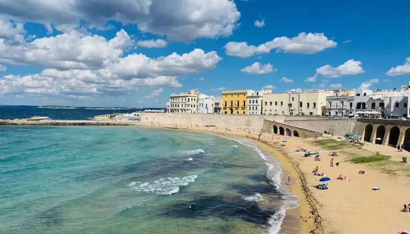 Sonne, Strand und Meer – ein gut mit Zug erreichbares Paradies. Türkisfarbenes Wasser trifft auf Sandstrand und weiße Häuser.