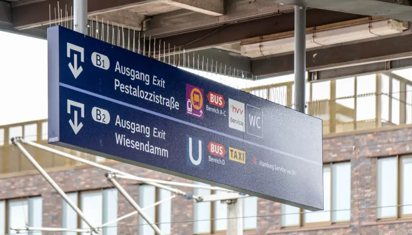 Wegweiser an einem Bahnsteig: Ausgang B1 zur Pestalozzistraße, B2 zum Wiesendamm, Bus, Taxi und WC.