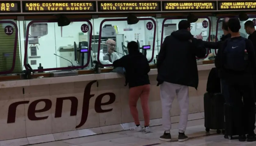 Menschen kaufen am Schalter der Renfe Fahrkarten für den Madrid Paris Zug.