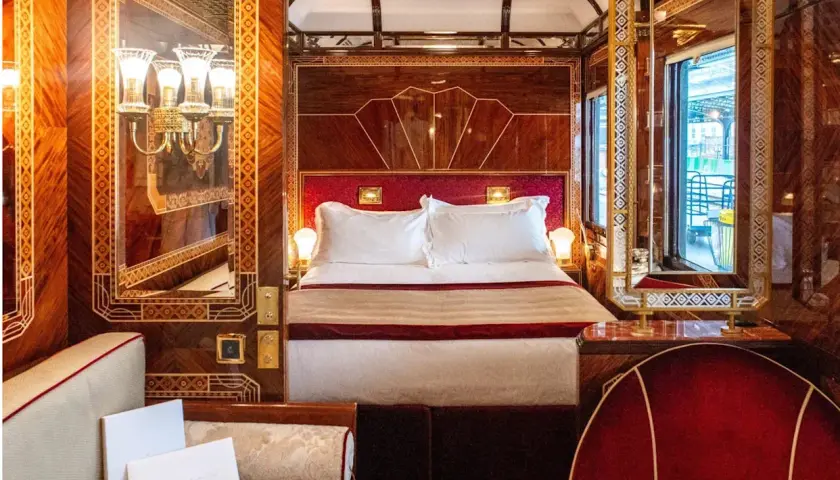 Luxuriöses Schlafabteil im Orient Express mit Doppelbett, Spiegeln und Mahagoni-Verzierungen.