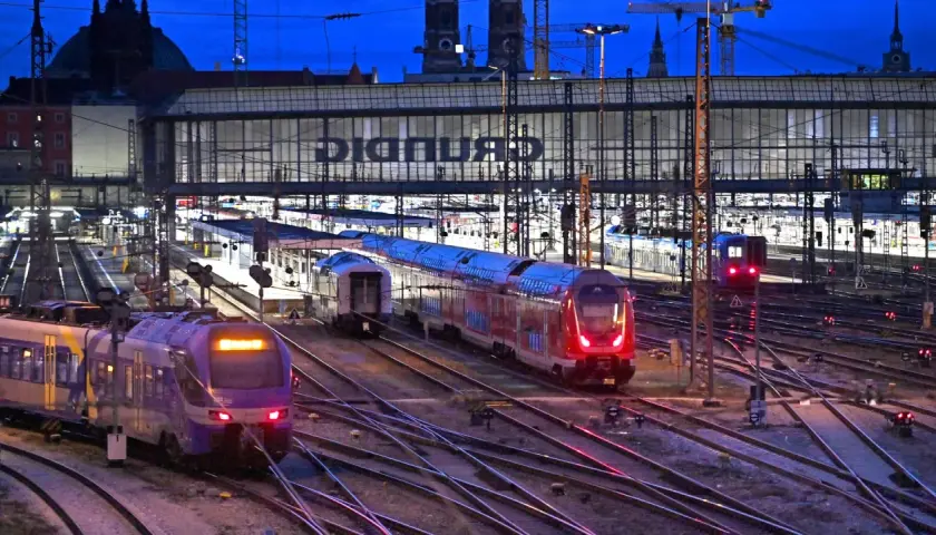 Züge auf einem beleuchteten Deutschland Bahnhof bei Nacht.
