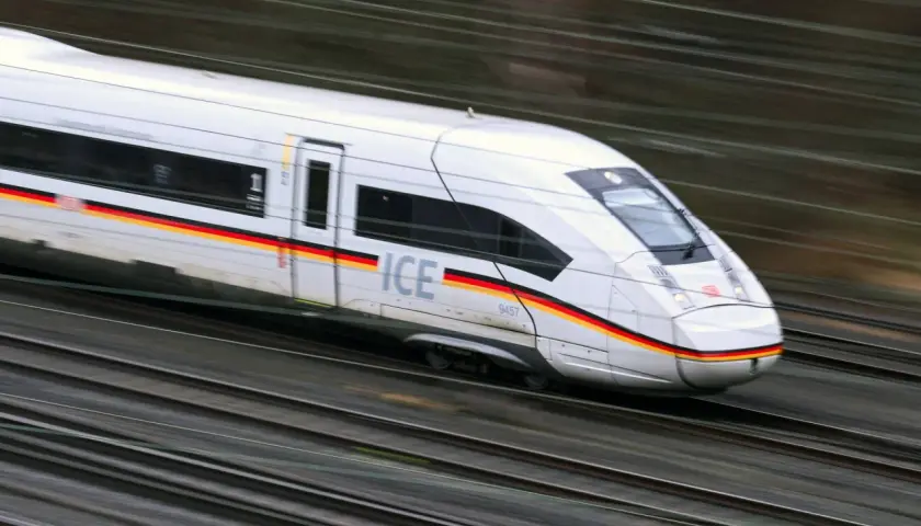 Schneller ICE-Zug mit deutscher Flagge auf der Seite rast auf den Gleisen. Die Reise von Paris nach Zürich beginnt.