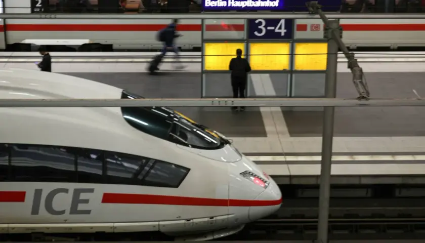 Ein ICE-Zug am Berliner Hauptbahnhof. Reisende warten auf Gleis 3-4.