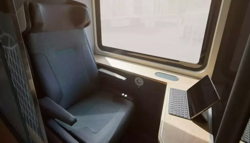 Komfortabler Sitzplatz im ICE-Zug mit Tisch und Tablet. Perfekt für die Arbeit unterwegs.