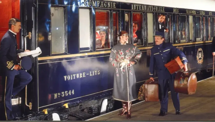 Luxuriöser Zug für die Reise von Venedig nach Florenz. Ein Schaffner hilft einer Dame mit Gepäck beim Einsteigen.