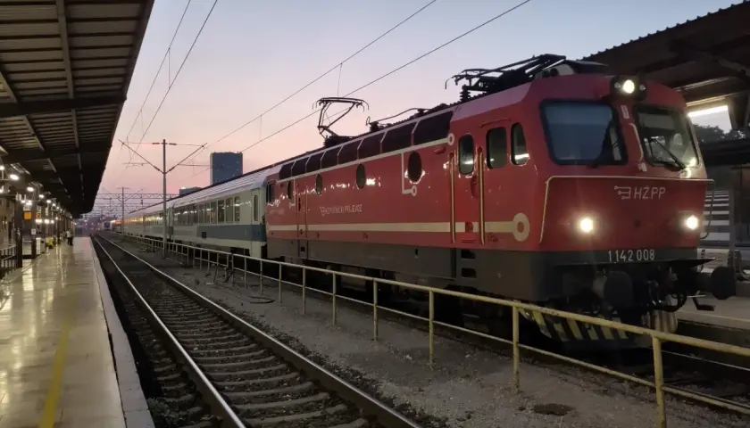 Roter Zug mit HZ PP Logo am Zagreb Hauptbahnhof im Abendlicht.