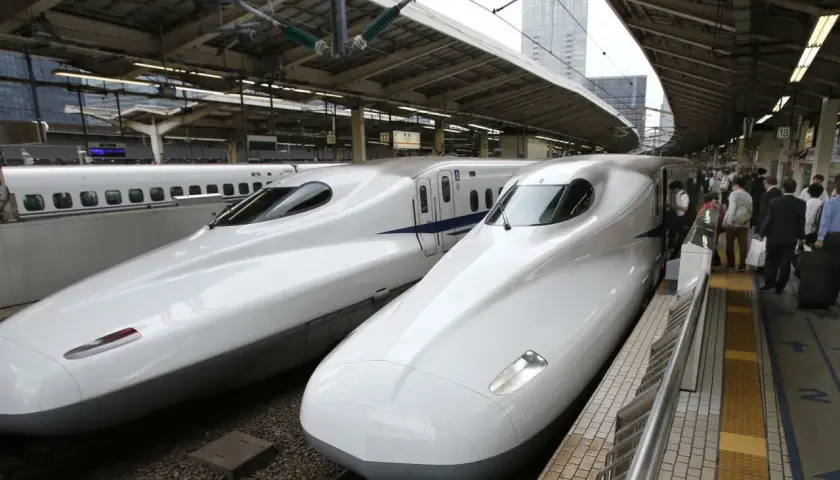 Zwei weiße Shinkansen-Züge stehen nebeneinander auf einem Bahnhof. Sie sind ein Symbol für die effizienten Zugverbindungen Japans.