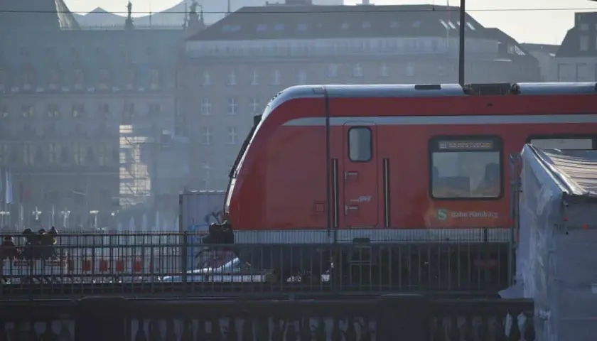 Roter Zug der Bahn Hamburg fährt durch die Stadt. Eine Reise mit dem Zug durch Deutschland beginnt hier.