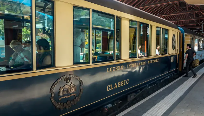Der Zug der GoldenPass Line fährt von Luzern nach Interlaken. Passagiere genießen die Aussicht auf der Fahrt von Zürich nach Genf.