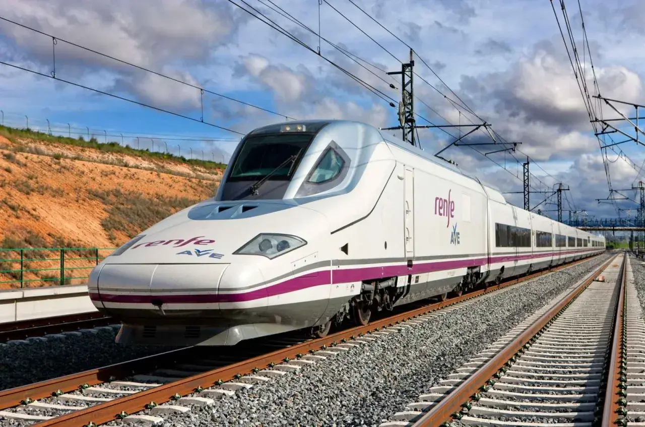 Weißer Hochgeschwindigkeitszug AVE von Renfe fährt auf Gleisen.