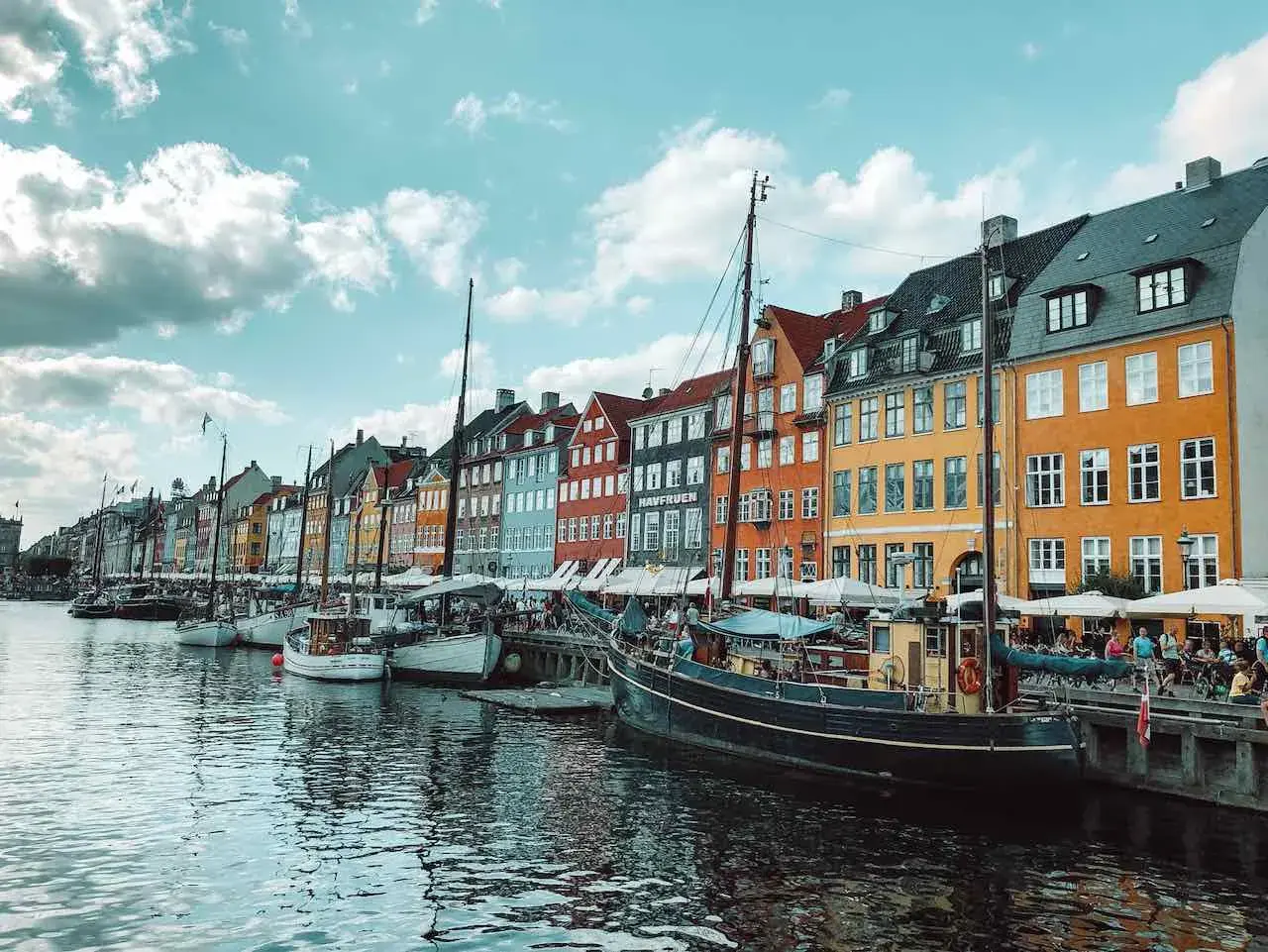 Bunte Häuser am Nyhavn-Kanal in Kopenhagen, Dänemark. Boote liegen im Wasser, ein perfekter Ort nach der **train to Copenhagen**.