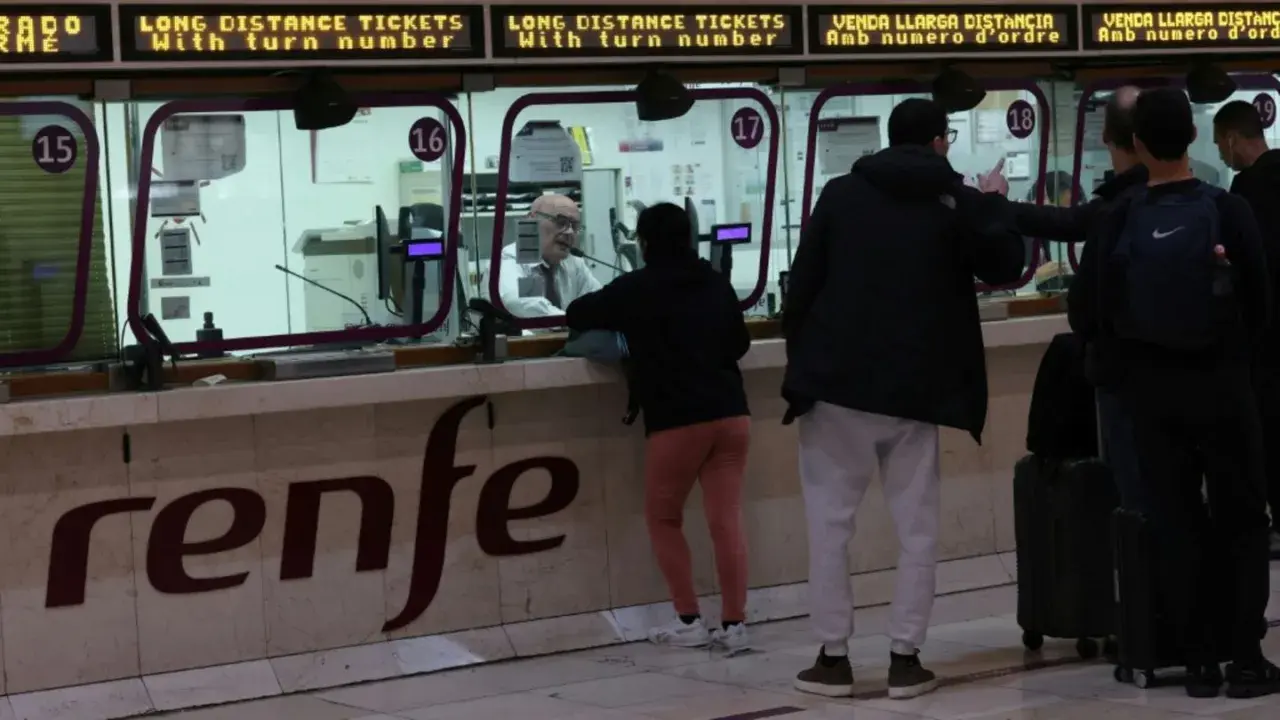 Menschen kaufen am Schalter der Renfe Fahrkarten für den Madrid Paris Zug.