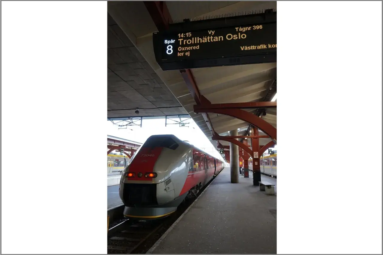 Moderner Zug am Bahnsteig, Anzeigetafel zeigt "Trollhättan Oslo".